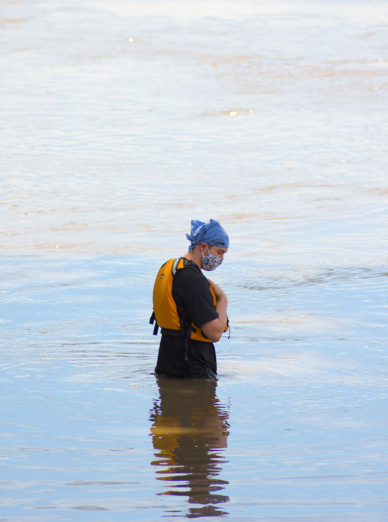 Volunteer Matthew Hall waits for racers in the water